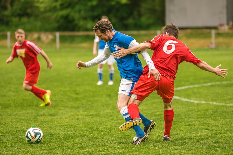 outdoors, kicking, action, rush, football, soccer player, sports Uniform, full length, kicker, soccer shoes, footballs, group of people, soccer, grass