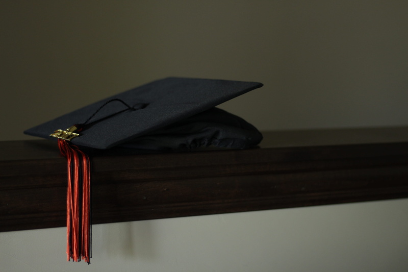 studio shot, no people, orange, black, indoors, celebration, wood - material, learning, success, mortarboard, close-up, book, publication, hat, still life