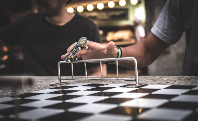 human hand, fingerboarding, holding, crossword puzzle, leisure activity, man, floor, adult, trademark, flooring, ping pong, playing, women, occupation