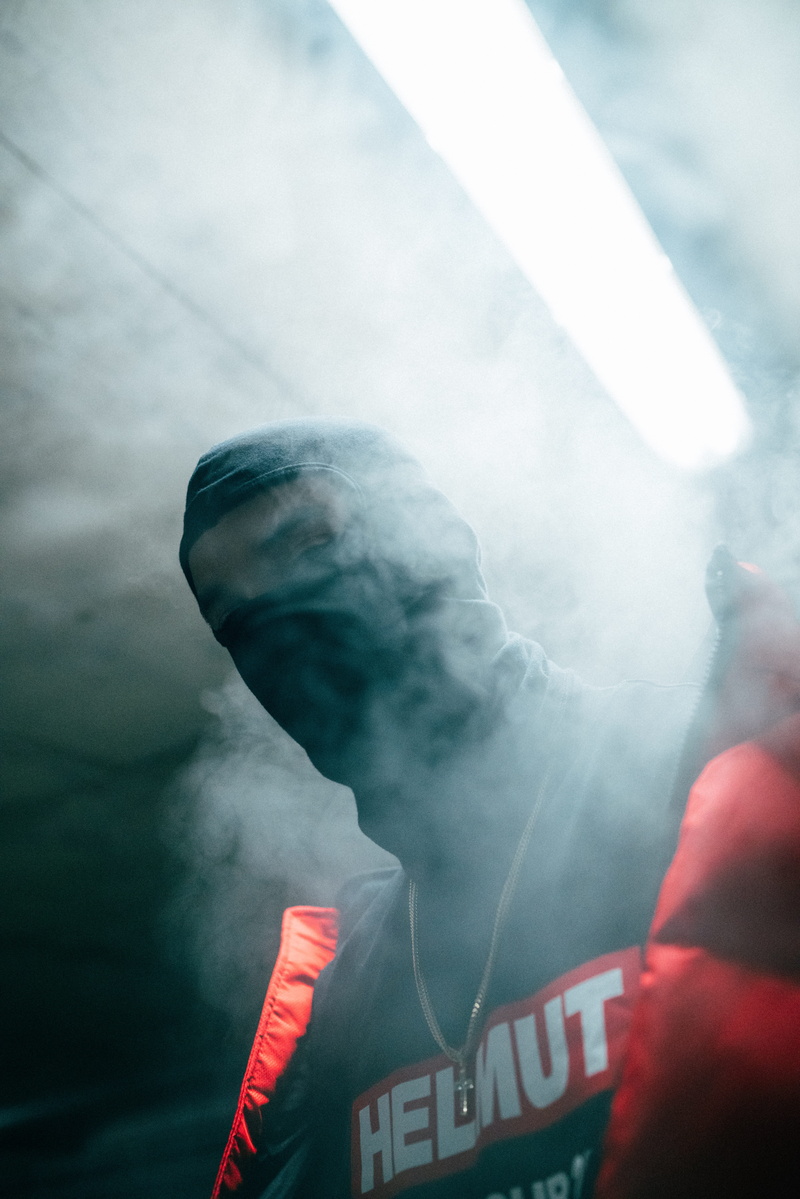 wearing, obscured face, low angle view, outdoors, smoke - physical structure, 8K, smoke, rear view, standing, mask, communication, real people, day, lifestyles