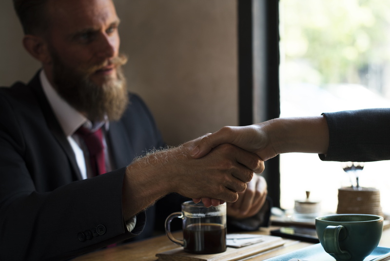 mug, cup, seated, facial hair, shaking, hand, indoors, togetherness, barista, blazer, front, business people, deal, drink, restaurant, talking, one man only