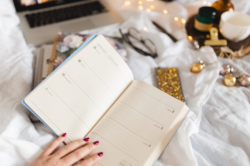 celebration, book, christmas, lifestyles, holding, bed, preparation, paper, human body part, notebook, agenda, indoors, work, publication, one person, high angle view