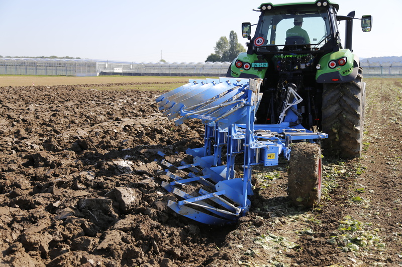 machine, land vehicle, field, wheel, tractor, day, machinery, tire, no people, farmer, land, cultivation, harvest, sky, arable, sunlight, agricultural equipment