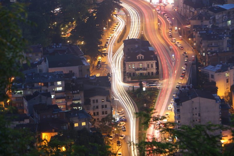 city street, built structure, architecture, street, mode of transportation, tree, trabzon bar association, motion, city, outdoors, illuminated, light trail