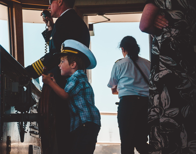 leisure activity, hat, women, togetherness, indoors, wheel, son, wearing, speak, lifestyles, males, child, captain, captin, ship, learn, beside, boy, men