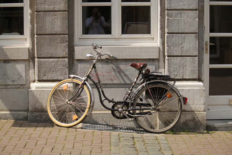 mature, street, spoke, city, gray, ladys bike, building exterior, commuter, ajar, black and gray, house facade, land vehicle, dutch, next, sidewalk, built structure
