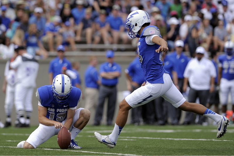 incidental people, sports helmet, teenager, attempt, college, teams, competition, ball, focus on foreground, points, outdoors, playing, place, football