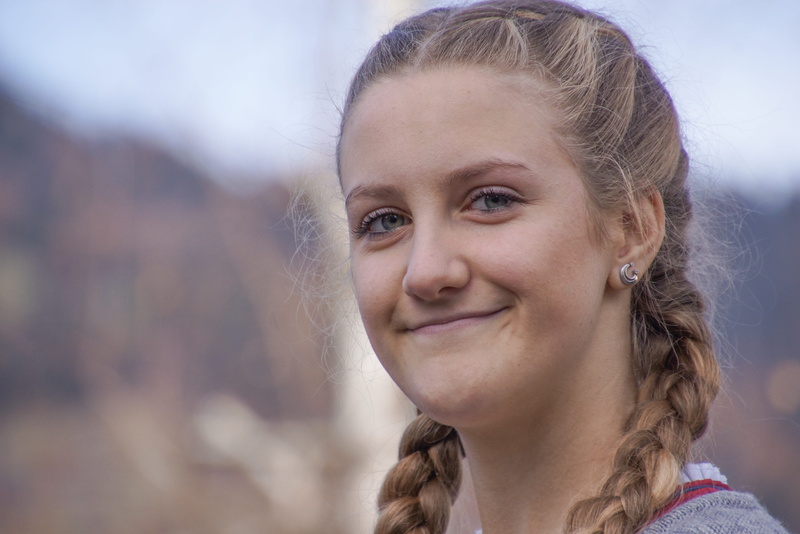 smiling, outdoors, human face, portrait, emotion, 4K, braids, courageous, strong, looking at camera, optimistic, focus on foreground, nature, woman, front view