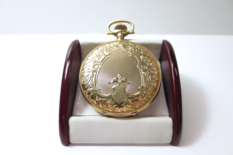 engraved, financial, metal, white background, craft, success, jewelry, gain, strategy, watch, no people, mechanism, indoors, progress, scroll, solid, mechanical