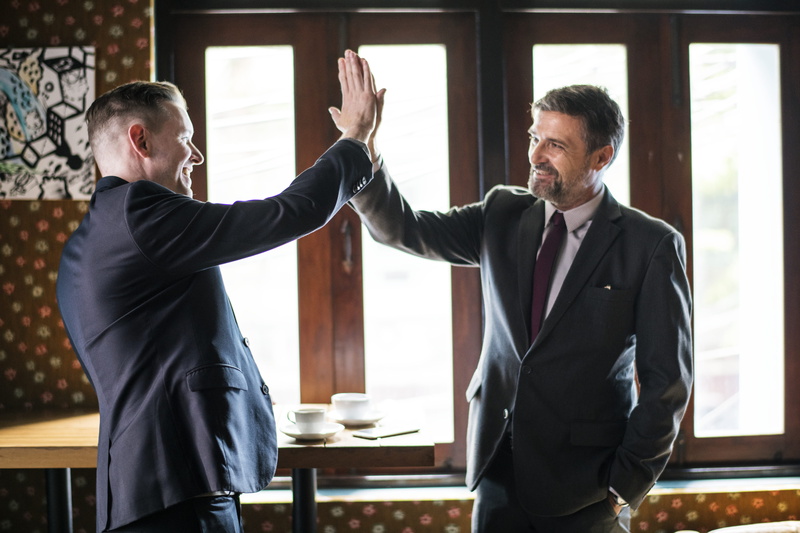 well-dressed, adult, two, business person, business, corporate business, businesspeople, mature men, coffee cup, men, males, mid adult men, high five, businesswear