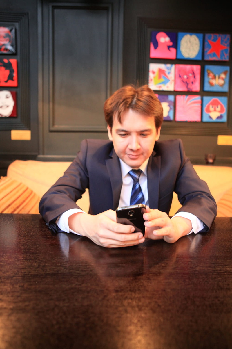 holding, furniture, suit, connection, table, person, handsome, communication, young, front view, businessman, wireless technology, indoors, 720P, man