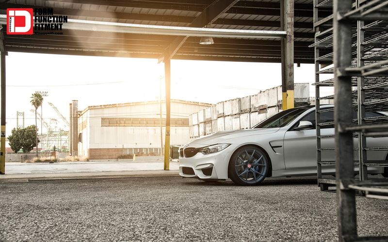 garage, motor vehicle, day, BMW M4, car, road, mode of transportation, street, outdoors, land vehicle, parking lot, parking garage, building, architecture