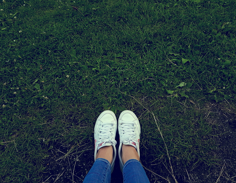 real people, wearing, person, sneakers, human body part, standing, feet, plant, low section, human Foot, field, one person, blue, green, leisure activity