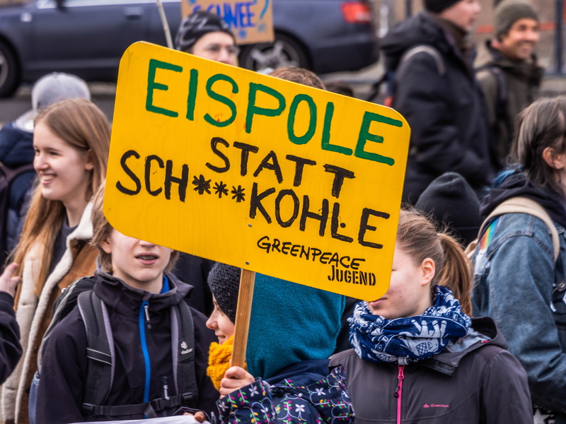 crowd, clothing, pedestrian, coat, person, real people, protest, text, hand, social issues, woman, rally, offroad, car, automobile, outdoors, jacket, communication
