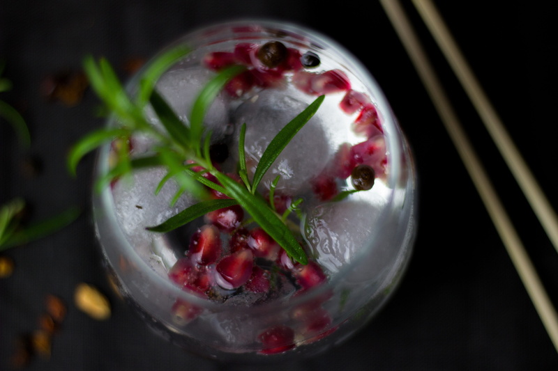 black background, indoors, glass, healthy eating, focus on foreground, cocktail bar, ice cube, refreshment, close-up, bar, pomegranate, rosemary, wellbeing