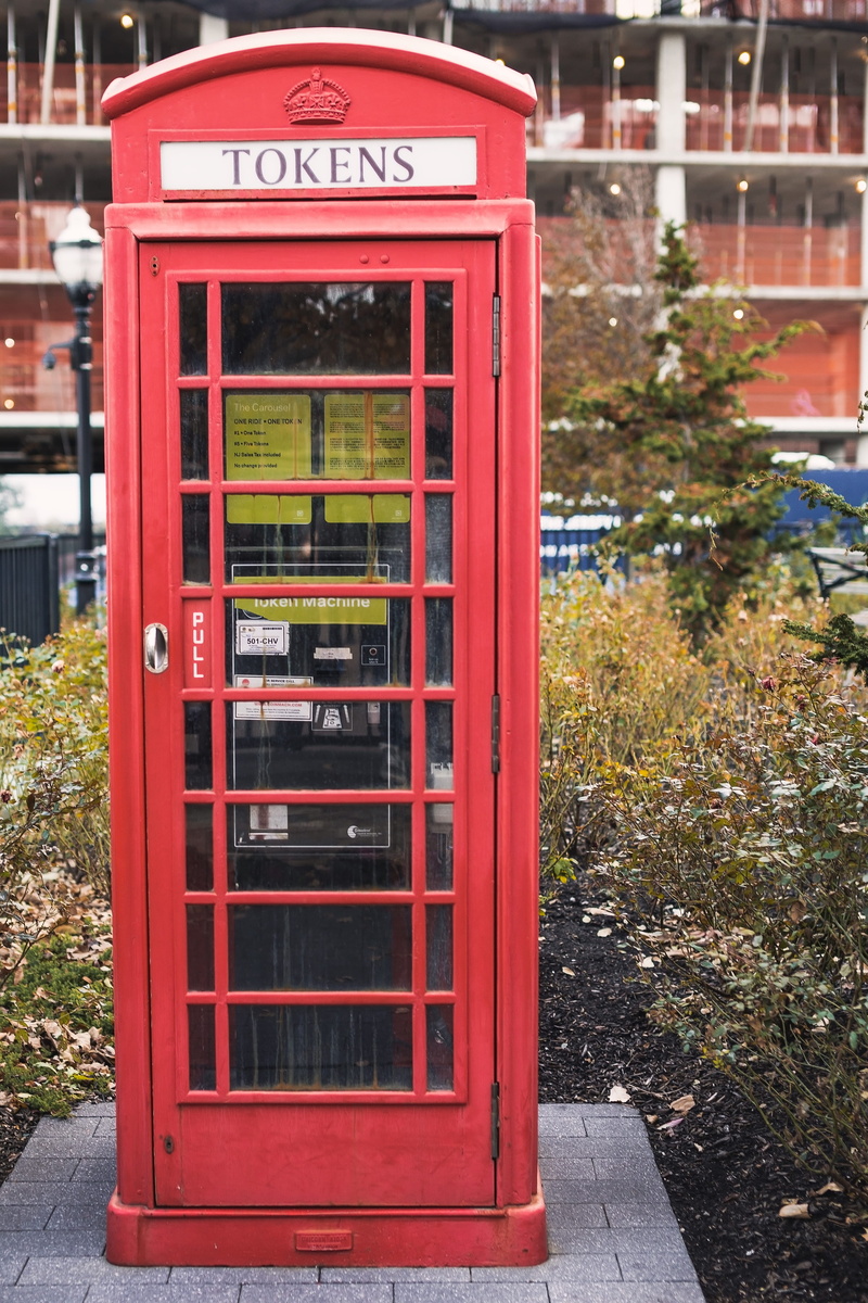 telephone, global communications, red, technology, kiosk, outdoors, western script, sidewalk, grass, no people, urban, vase, building, convenience, telephone booth