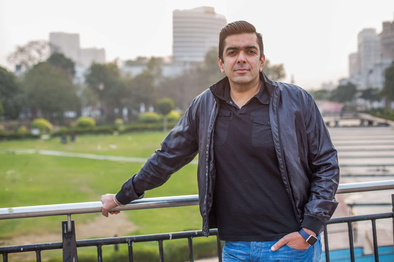 leather jacket, railing, portrait, young men, jacket, focus on foreground, casual clothing, city, built structure, front view, outdoors, waist up, clothing