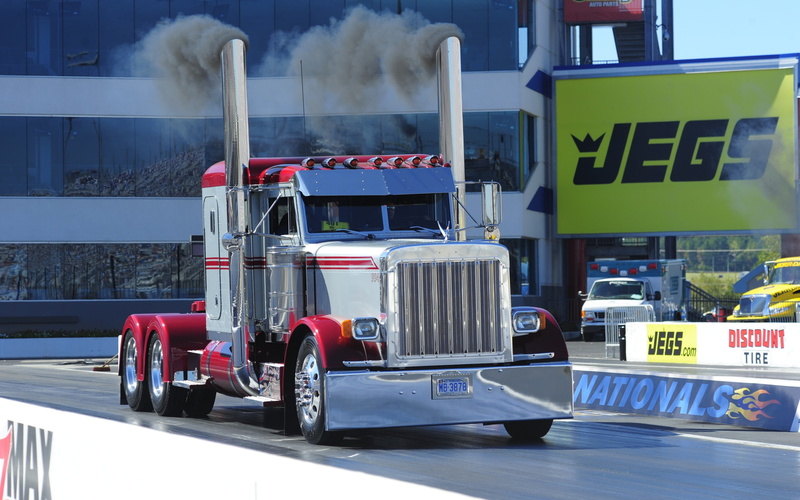 smoke - physical structure, western script, day, road, communication, transportation, sunlight, race tracks, drag, outdoors, car, motor vehicle, text, mode of transportation