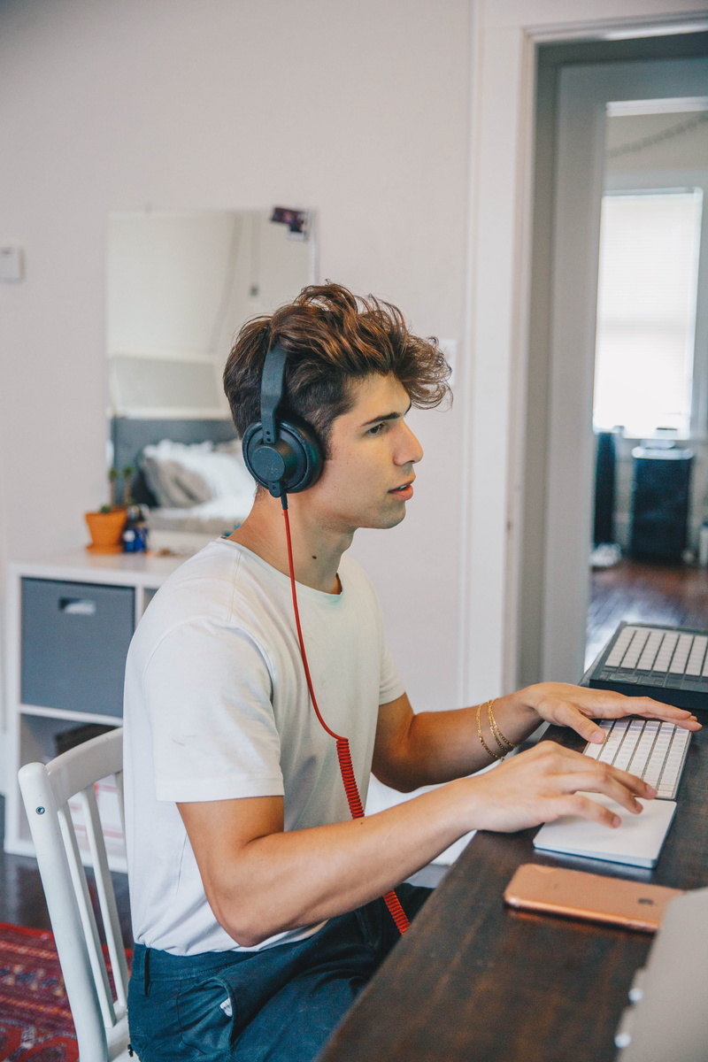 adult, keyboard, pc, using laptop, 5K, furniture, headphones, person, communication, table, black, waist up, human, man, concentration, screen, chair