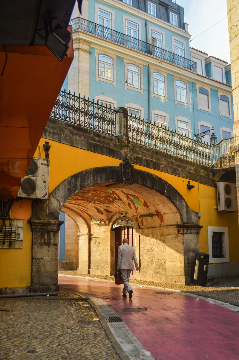 men, women, one person, downtown, built structure, real people, umbrella, building, city, portugal, outdoors, pink street, street, architecture, lifestyles
