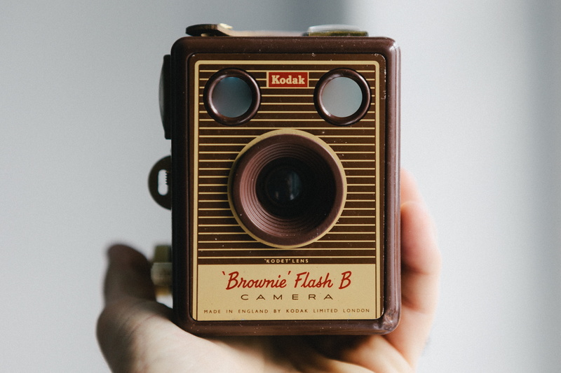 b, brownie, 5K, technology, studio shot, flash, hand, human hand, history, box, front view, the past, kodak, close-up, person, text, retro styled, single object