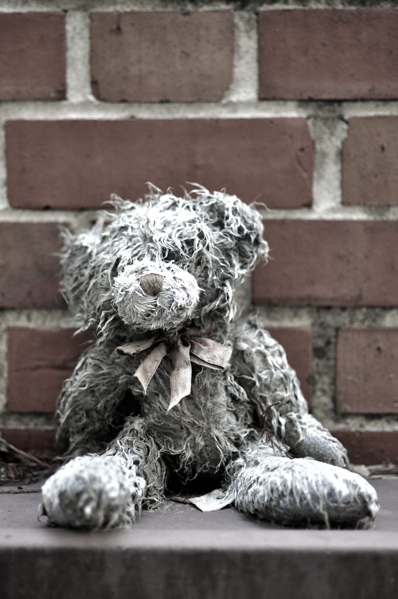 stuff animal, built structure, toy, sad, outdoors, sculpture, brick, bricks, craft, brick wall, teddy bear, animal themes, lonely, mammal, animal representation