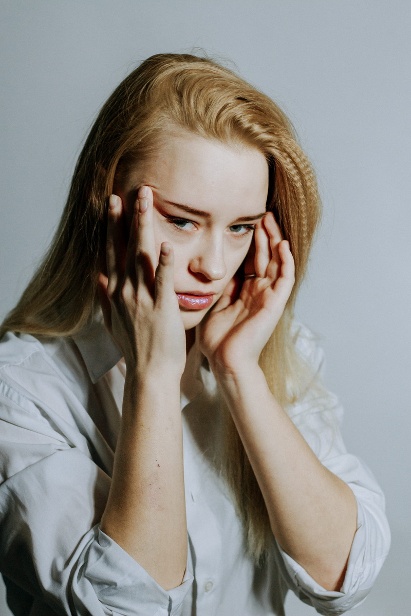 front view, head in hands, photo, stress, young adult, studio shot, hairstyle, beauty, headache, 5K, beautiful woman, portrait, pain, human face, gray background