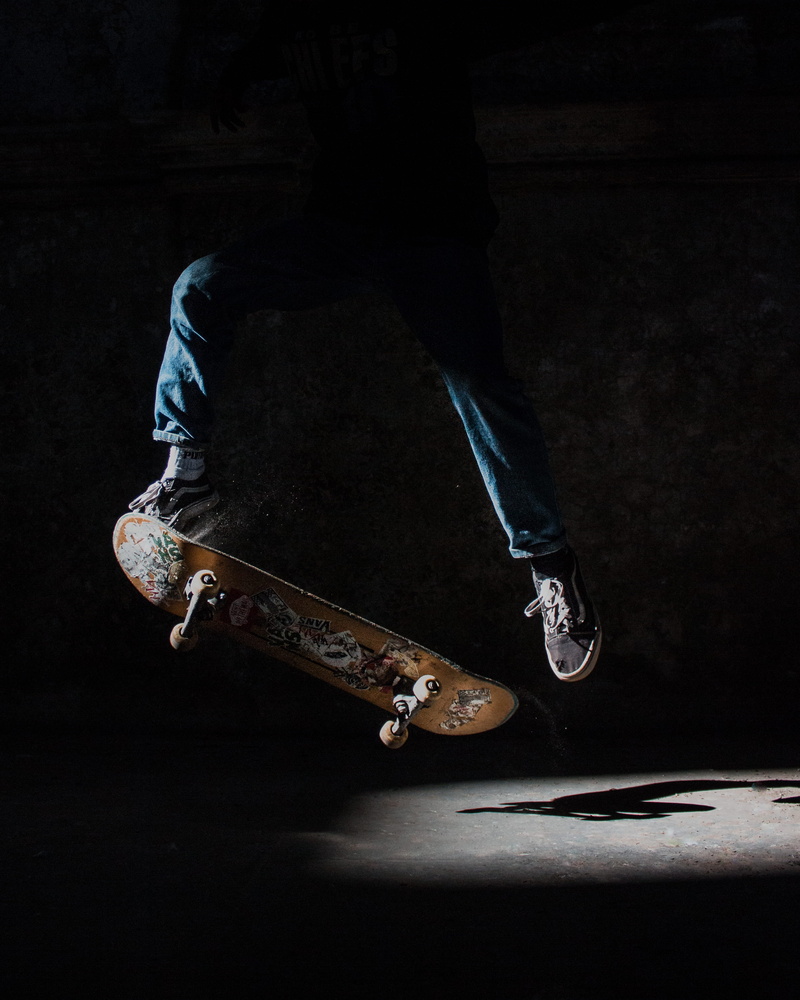 footwear, indoors, human foot, human body part, dark, kickflip, using, human, skateboarding, black background, vans, leisure activity, skill, jeans, one person