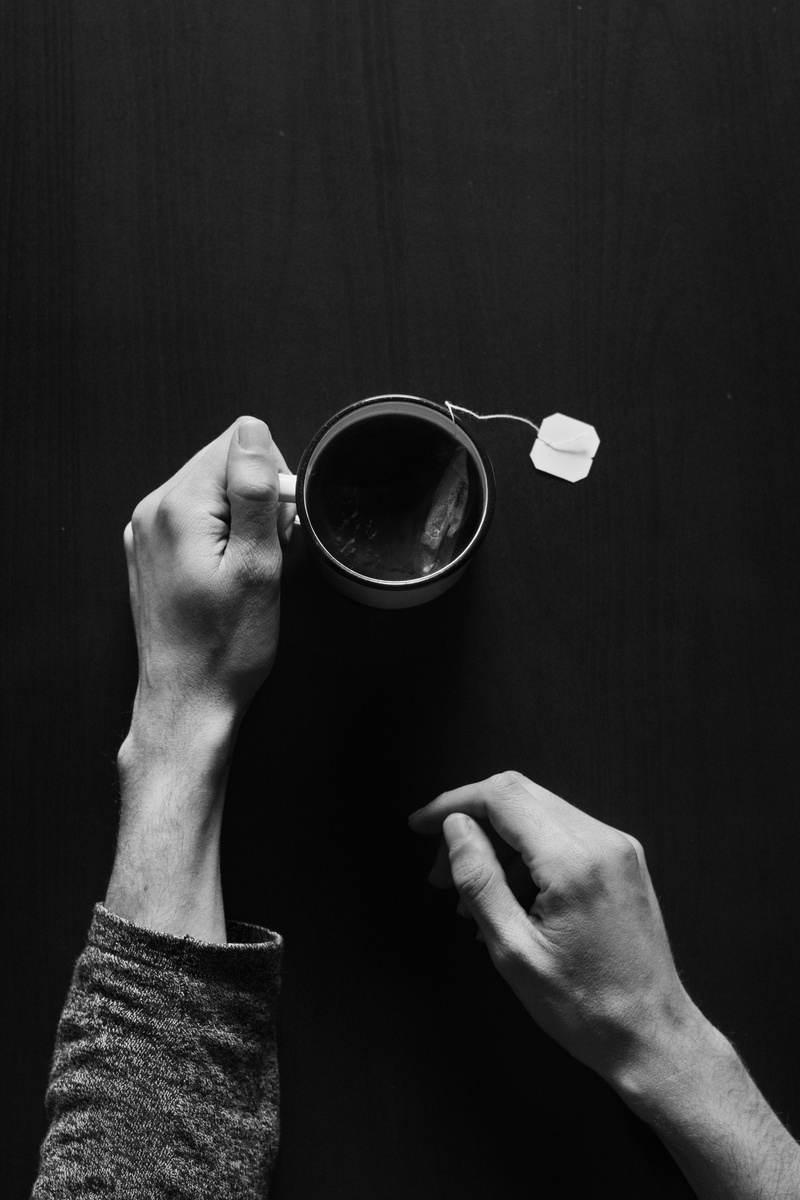 human body part, goggles, hole, dip, personal perspective, drinking, coffee cup, lay, lifestyles, hand, brass section, glass, tea, money, rubix cube, black background
