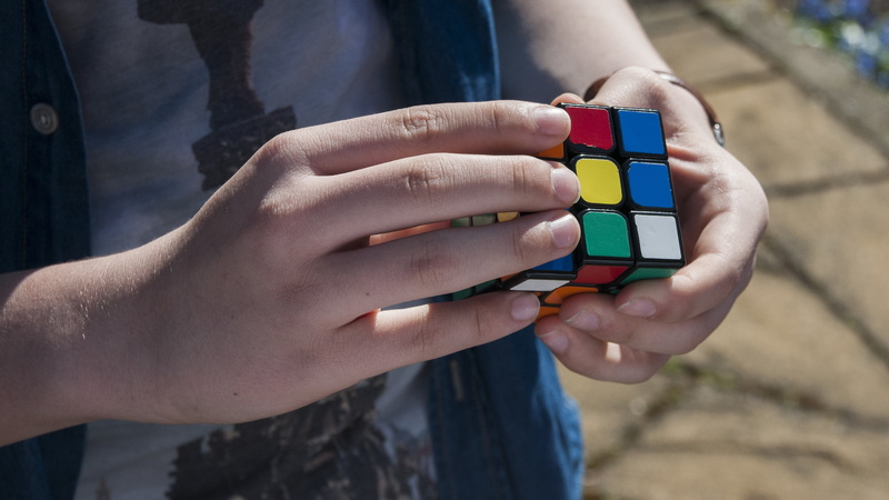 multi colored, hand, people, cube, rubik, adult, holding, outdoors, one person, young adult, one woman only, day, women, youth, fingers, focus on foreground