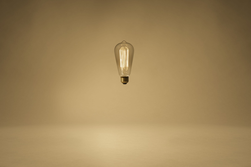 glass, motion, clear, studio shot, hovering light bulb, edison light bulb, reflect, 5K, float, light, orange background, copy space, electric lamp, filament