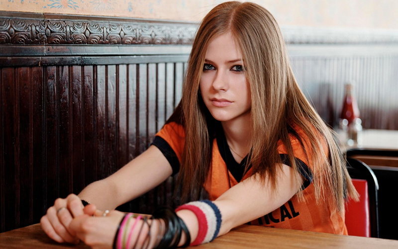 looking at camera, lifestyles, one person, long hair, beauty, girls, blonde, women, casual clothing, blue eyes, Avril Lavigne, real people, table, beautiful woman