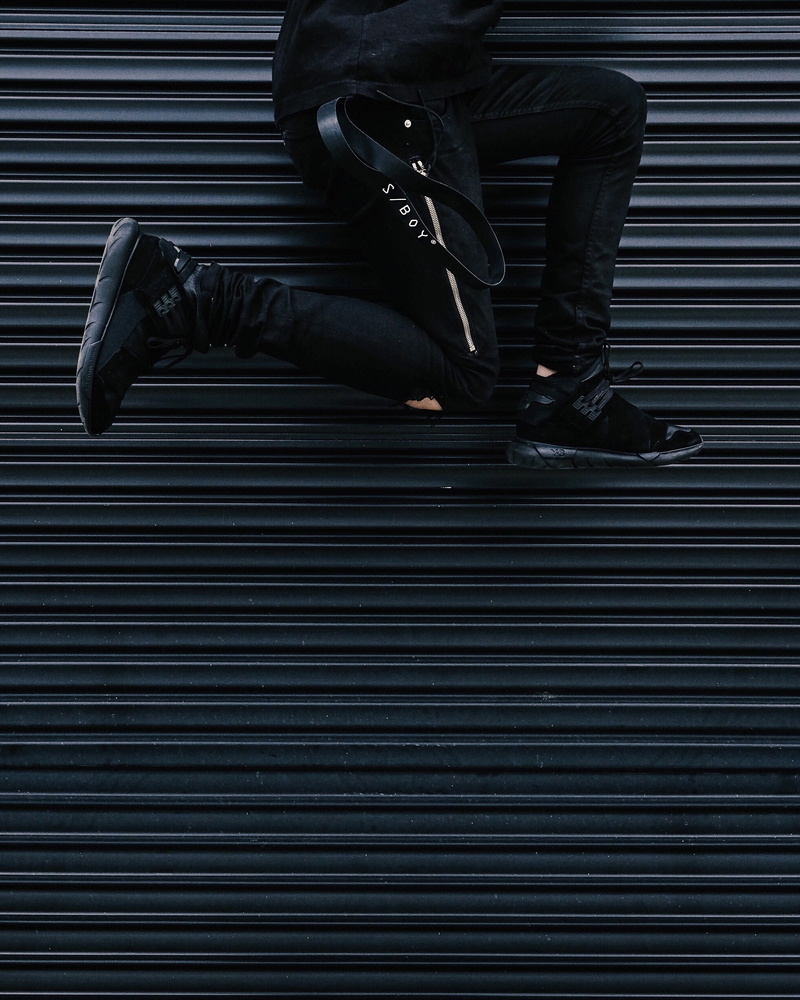 yeezu, sitting, human body part, jeans, expensive, protection, adult, jump, unrecognizable person, gate, person, black, mr completely, one person, steel