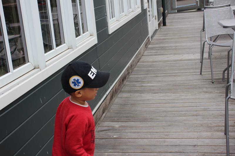 human, boardwalk, long sleeve, day, plan, sleeve, cap, child, waist up, porch, males, men, deck, apparel, chair, hat, childhood, three quarter length, built structure