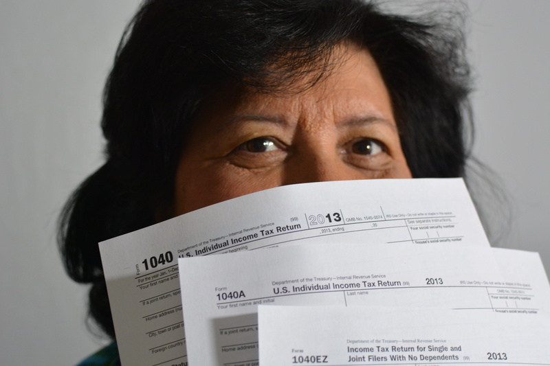 studio shot, black hair, front view, body part, looking at camera, woman, fees, adult, portrait, paperwork, human face, tax, close-up, human body part
