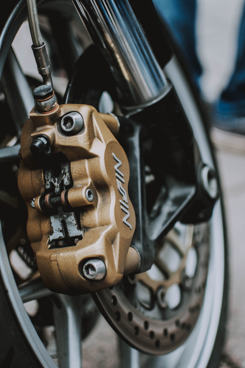 photo, high angle view, machine part, motorcycle, technology, brake caliper, transportation, engine, day, mode of transportation, close-up, depth of field
