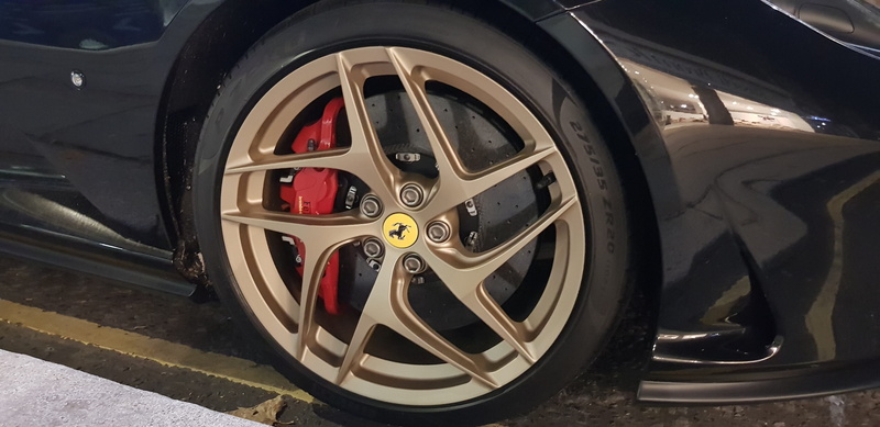 street, focus on foreground, close-up, transportation, motor vehicle, sports car, land vehicle, spoke, ferrari, silver colored, metal, wealth, travel, brake caliper