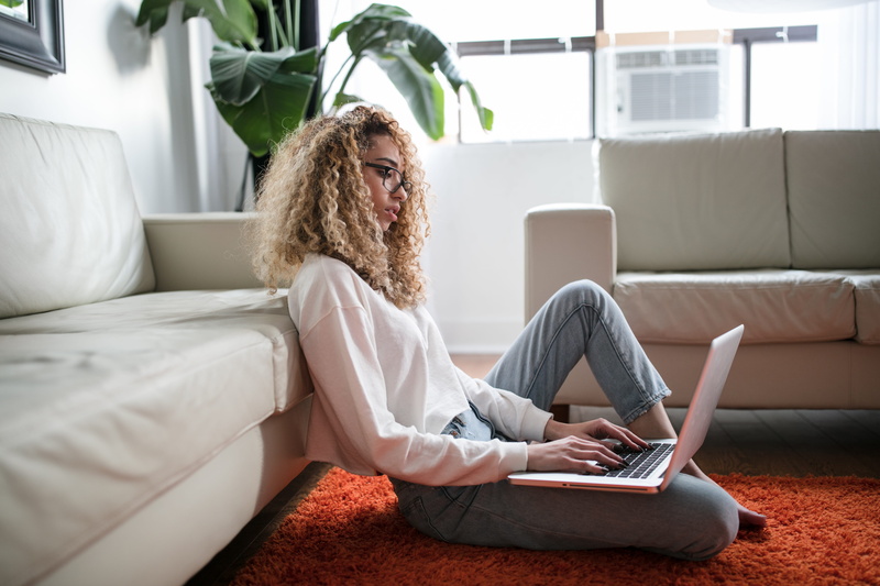 domestic life, interior, blond hair, connection, hairstyle, computer, furniture, living room, communication, person, woman, screen, laptop, technology