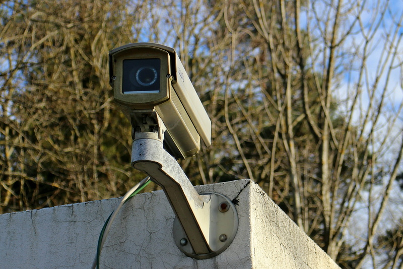 lack of dom, 2K, sunlight, security system, wall, camera, outdoors, metal, supervision, nature, surveillance camera, communication, focus on foreground