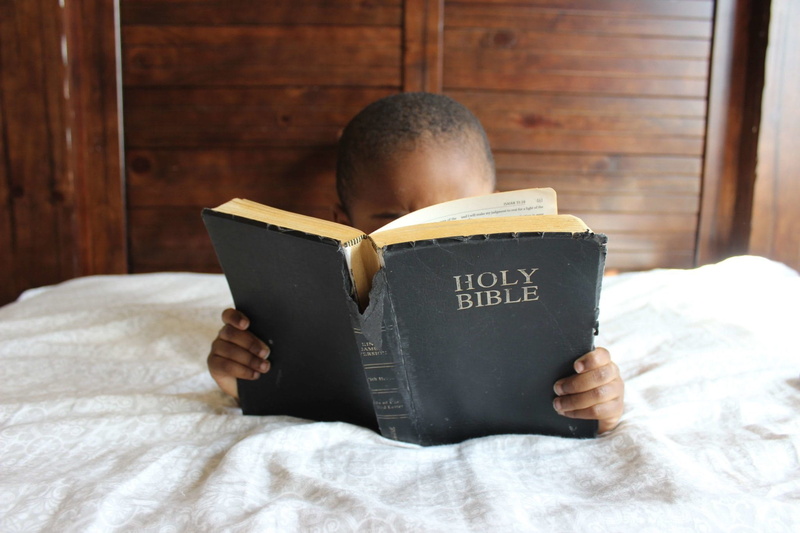 leisure, child, obscured face, publication, domestic room, activity, western script, photo, relaxation, person, furniture, religious, one person, front view