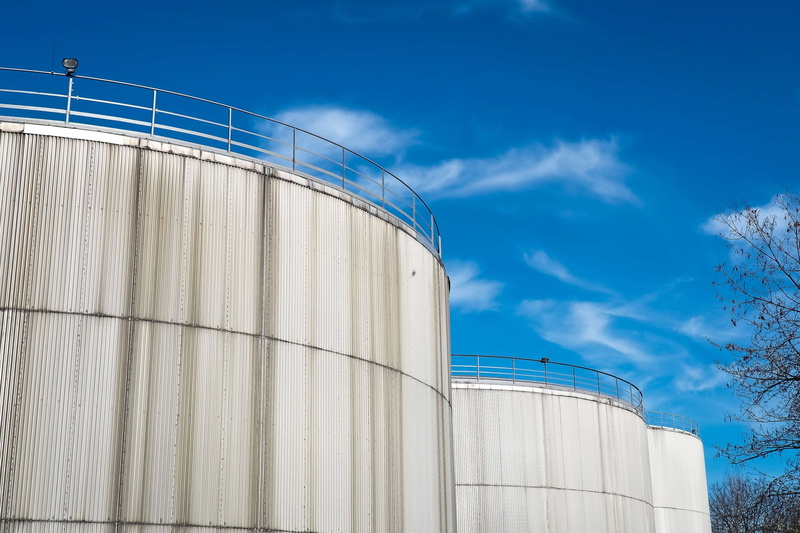 fuel storage tank, steel, outdoors, low angle view, blue, gasoline tanks, architecture, inland port, storage tank, cloud - sky, fuel, industrial plant