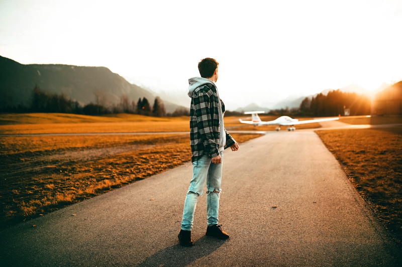 person, photoshoot, runway, dawn, full length, gray, aircraft, standing, hoodie, looking, transportation, adult, sunrise, young adult, casual clothing