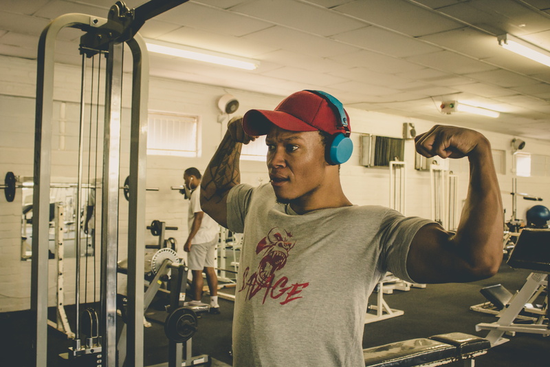 tattoo, working out, real people, weapon, sport, apparel, adult, exercise, front view, shooting range, baseball cap, human, muscular build, young adult