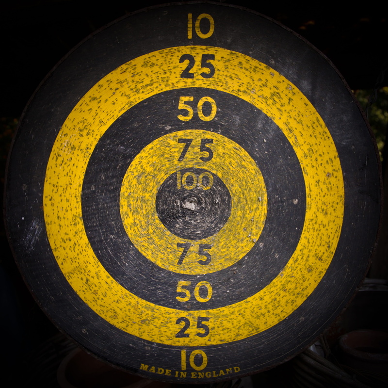 communication, delivering, black color, play darts, outdoors, no people, day, target, middle, shape, disc, text, number, accuracy, yellow, board, bulls eye