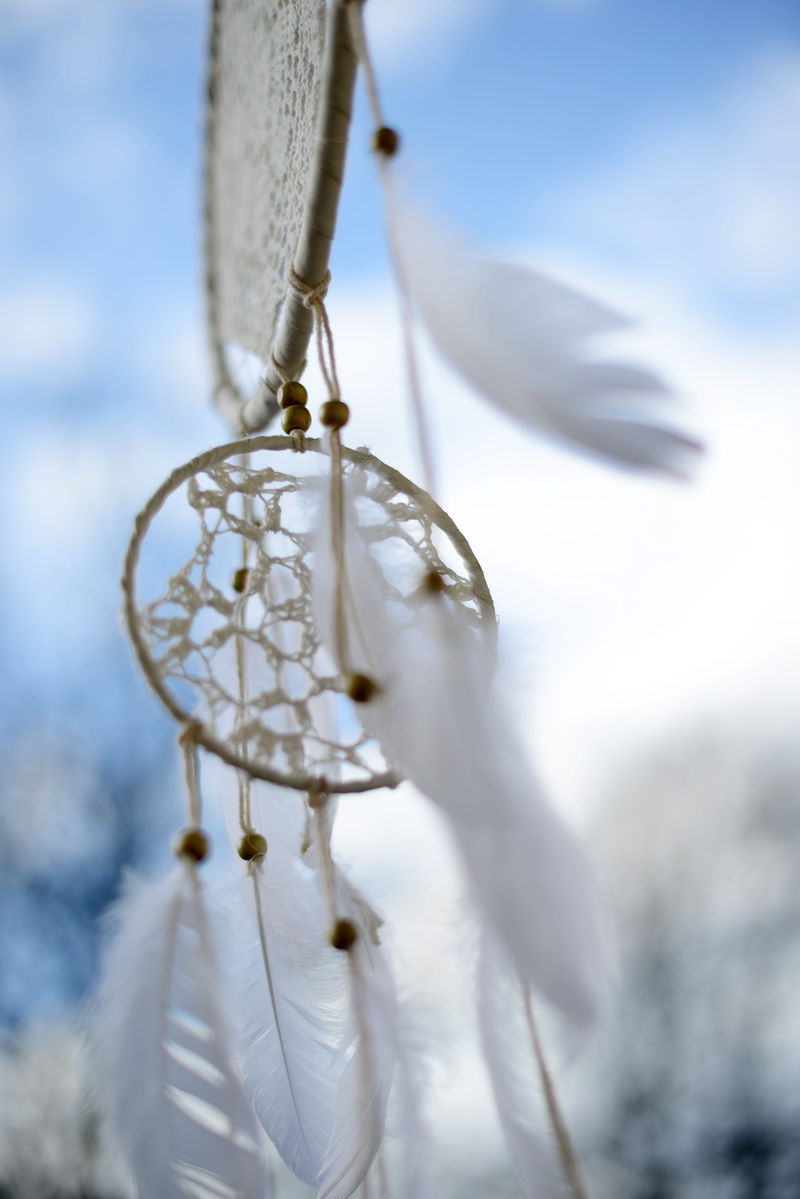 decoration, outdoors,, hanging, dreamcatcher, hippie, close-up, art and craft, spiritual, belief, feather, focus on foreground, white color