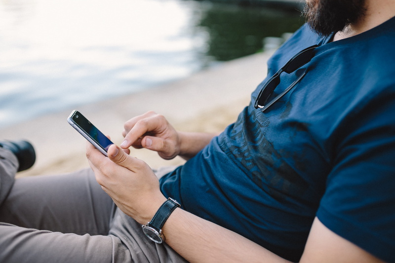 casual Clothing, Young, internet, lifestyles, watch, outdoors, men, focus on foreground, midsection, summer, males, people, adults Only, relaxation, holding