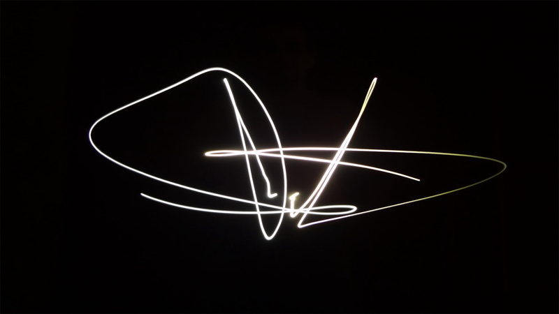  indoors, light - natural phenomenon, line, light painting, night, communication, neon, studio shot, electricity, signature, motion, symbol, emotion