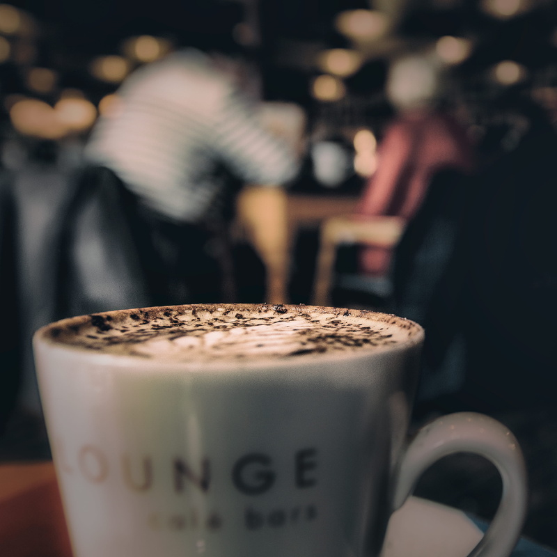 indoors, incidental people, coffee shop, close-up, 2K, caffeine, refreshment, coffee, mug, focus on foreground, coffee Cup, close up, people, hot drink