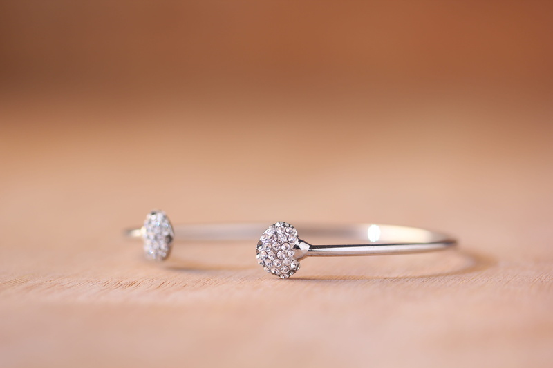copy space, silver colored, ring, expense, blur, studio shot, engagement ring, celebration, wealth, shiny, luxury, selective focus, jewelry, table, wood - material