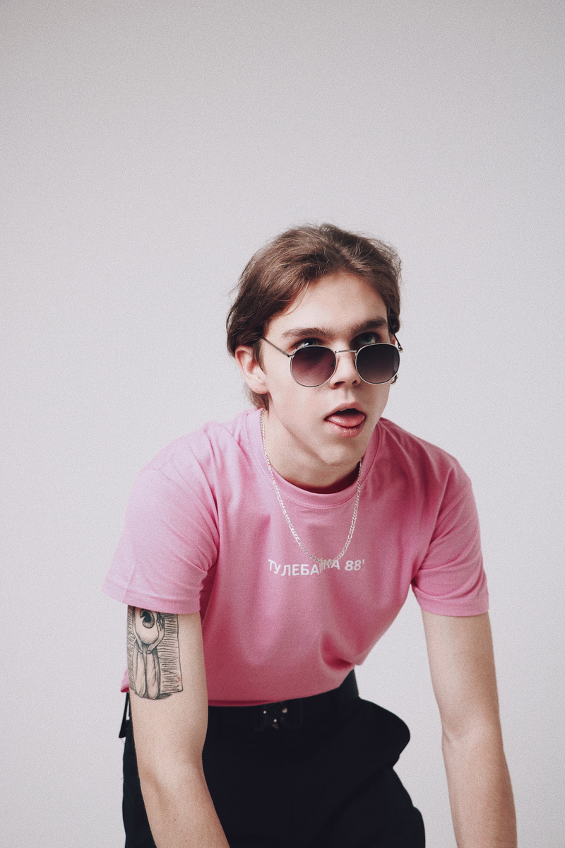 wearing, indoors, studio shot, wall - building feature, standing, shirt, long sleeve, teenager, young men, tattoo, one person, accessory, sunglasses, musician